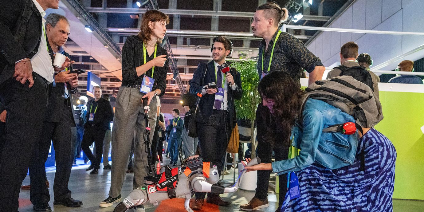 AI-forskaren Soraya Ghassemlou hälsar på en robothund under en AI-konferens i Montreal i Kanada tidigare i september.