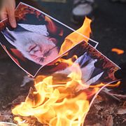 En demonstrant bränner en bild av Irans tidigare högste ledare ayatolla Ali Khamenei under en protest i Kanada.