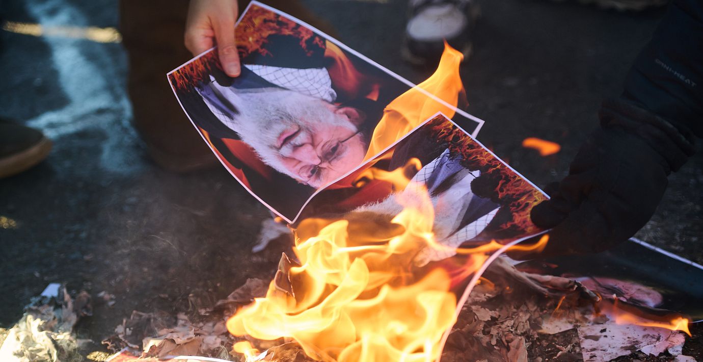 En demonstrant bränner en bild av Irans tidigare högste ledare ayatolla Ali Khamenei under en protest i Kanada.