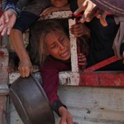 Palestinier försöker få mat vid ett nödhjälpscentrum i Gaza.