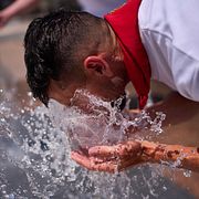 En man i Pamplona svalkar sig den 7 juli.