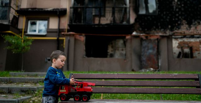 Yarik leker vid en förstörd byggnad i Irpin 30 maj. Natacha Pisarenko / AP