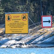 En varningsskylt  i skärgården nära Musköbasen informerar om skyddsobjekt, tillträde förbjudet och fotografering förbjuden.
