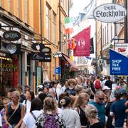 Turister och huvudstadsbor på gågatan Västerlånggatan i Gamla stan i Stockholm