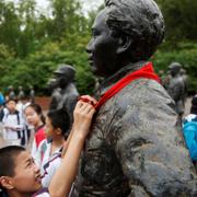 Skolelever sätter en halsduk på en staty av Mao Zedong som finns i en privat samling i staden Anren.