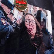 En demonstrant har en bild av Jelena Grigorjeva på sin tröja.