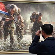 En besökare tittar på en nationalistisk målning på en konsthall i Pyongyang i Nordkorea.