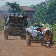 Kambodjaner kör bakom ett militärfordon för evakuering i Oddar Meanchey-provinsen, Kambodja, under fredagen.
