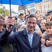 Moderaternas partiledare Ulf Kristersson (M) med ungdomar då han valkampanjar vid Moderaternas valstuga på Stora torg i Kristianstad på torsdagen.