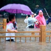 Folk vadar fram i vattenmassorna i staden Zhengzhou. 