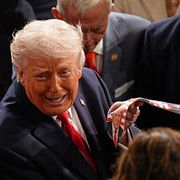 President Donald Trump  håller upp den republikanske representanthusledamoten Troy Nehls slips kort efter talet under natten till onsdagen. 