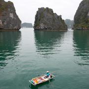 En kvinna i en båt i Ha-Long-bukten, Vietnam.