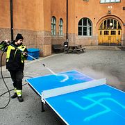 En person sanerar nazistiskt klotter på skolan Vasa Real i Stockholm. Arkivbild.