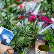 Blommor och ljus till minne av den mördade kvinnan.