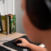 Pojke med hörlurar spelar datorspel