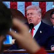 En man kollar på Donald Trumps tal på TV. 