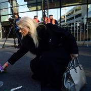 En kvinna lägger en blombukett på marken vid minnesstunden på flygplatsen i Bryssel, ett år efter terrordåden.