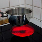 En kastrull med vatten på en spishäll. Illustrationsbild. 