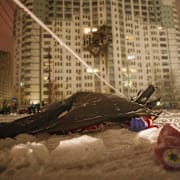 En död sjukvårdare ligger på marken utanför ett höghus i Kyiv som träffades i nattens attack mot Ukraina.