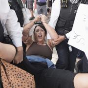 En kvinna förs iväg av polis under demonstrationerna. 