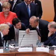 Angela Merkel tittar på när Donald Trump pratar med Turkiets utrikesminister Mevlut Cavusoglu och president Recep Tayyip Erdogan.