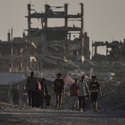 Människor bland bombade byggnader i Gaza stad, 17 augusti 2026.