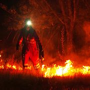 En brandman startar en kontrollerad brand i Ávila för att hejda skogsbrandens framfart.