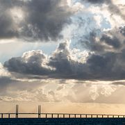 Arkivbild: Mörka moln med regn tornar upp sig över Öresundsbron medan solen är på väg ner i september 2018.