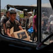 En palestinsk man med nödhjälp från GHF.