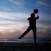 Pojkar spelar fotboll på stranden i Gaza City. Arkivbild. 