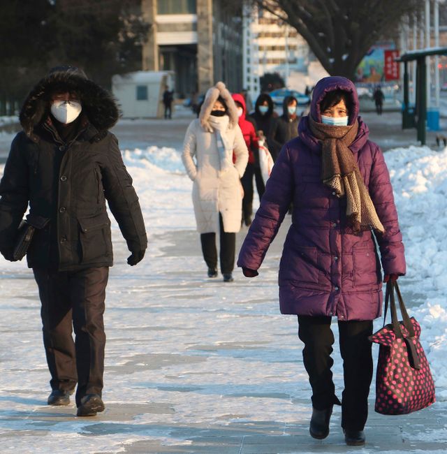 Pyongyang citizens walk on the snow-covered street of the city's central district in North Korea, Friday, Dec. 23, 2022. Cha Song Ho / AP