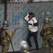 Polis omringar en demonstrant som protesterar mot regeringen i Kenyas huvudstad Nairobi i slutet av juni. 