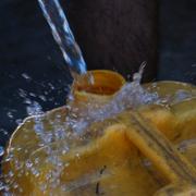 En palestinsk man fyller en plastdunk med vatten. Bilden är tagen tidigare i juli. 
