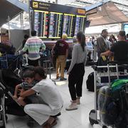 Strandsatta resenärer på flygplatsen i Bangkok. 