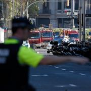 En polis bevakar en gata i Barcelona efter torsdagens terrorattentat, som krävt minst 13 människors liv. 