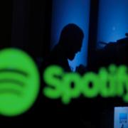 Börshandlare speglas i en datorskärm med Spotifys logga på Wall Street.