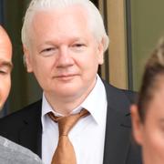 Julian Assange lämnar rättssalen i Saipan som en fri man. I bakgrunden syns Stephen Smith. 