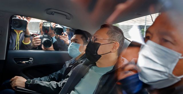 Den tidigare juridikprofessorn och oppositionelle Benny Tai sitter i en bil efter att  ha gripits i Hongkong.  TT NYHETSBYRÅN
