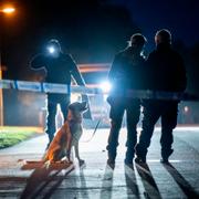 Polis med specialsökhund och kriminaltekniker arbetar innanför avspärrningarna i ett villaområde i centrala Skurup.