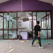 En thailändsk man inspekterar skadorna från en kambodjansk attack mot Thailand.