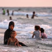 Palestinier svalkar sig i havet utanför staden Gaza, 2 juli 2025. 