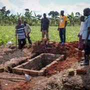 Släktingar till en kvinna som dött av ebola gräver en grav i Uganda. Personerna på bilden är inte omnäm 