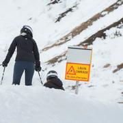 Skidåkare vis en skylt om lavinfara i Åre. Arkivbild. 