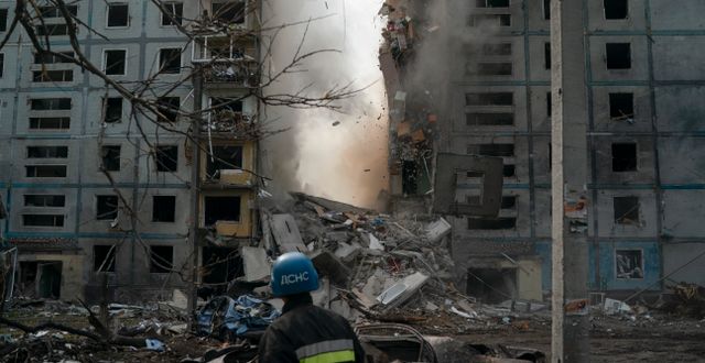 En brandman övervakar rasmassorna efter en byggnad som förstörts i en rysk attack i Zaporizjzja, 9 oktober 2022.  Leo Correa / AP