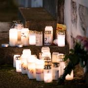 Ljus, godis och blommor utanför den fastighet där ett barn hittades livlöst i en lägenhet i centrala i Eslöv. Arkivbild från december 2022.