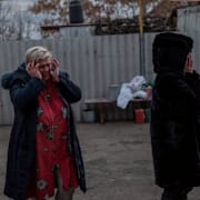 Skadad byggnad i Cherson/Sörjande Chersonbor.