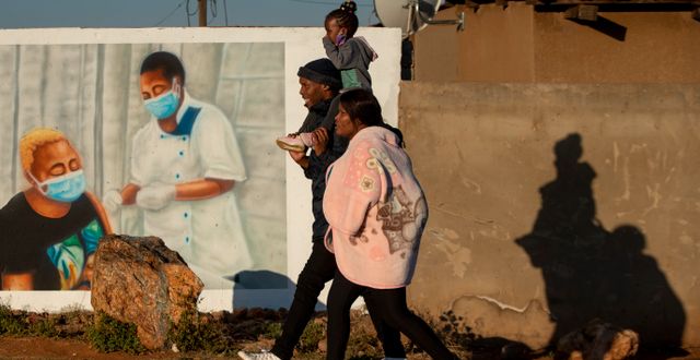 En familj går som går förbi en muralmålning i Sydafrika. Illustrationsbild.  Themba Hadebe / TT NYHETSBYRÅN