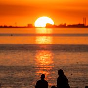 Solen sänker sig bakom Köpenhamns siluett när augusti bjuder på högsommarväder vid Öresund i Malmö på tisdagen.
