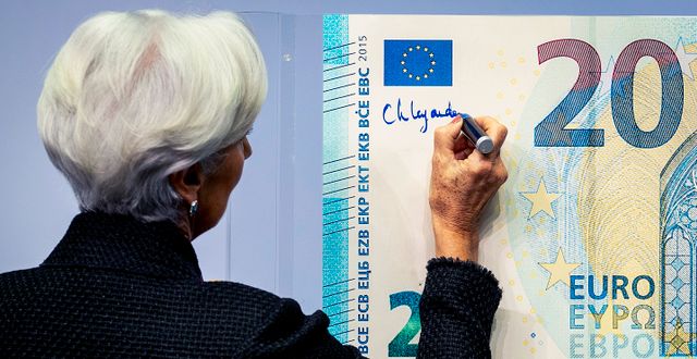 ECB:s centralbankschef Christine Lagarde signerar en eurosedel. Michael Probst / AP