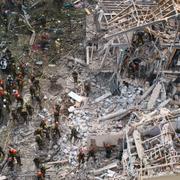 Brandkår, sjukvårdare och militär på plats vid ett bostadshus som skadats i morgonens attack på Tel Aviv. 